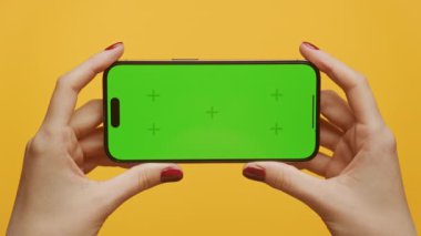 Sarı Arkaplanda Yatay Yeşil Ekran Akıllı Telefon POV, İşaretleyicilerle Krom Anahtarı Tutan Kadın Telefonu