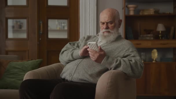 Großvater Benutzt Smartphone Sessel — Stockvideo