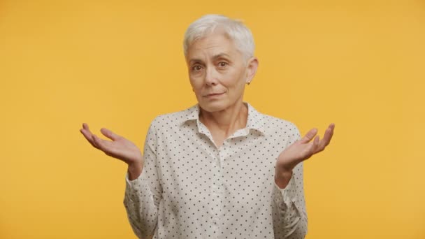 Starší Žena Pokrčení Ramen Nedostatek Volby Gesto Žlutém Pozadí — Stock video