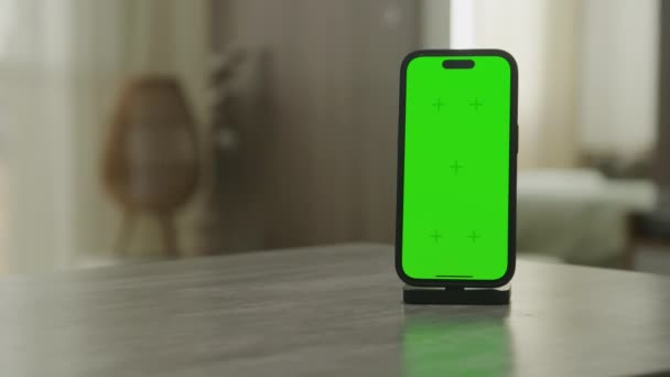 緑のスクリーン スマートフォンはクロマのキーのスマートな電話のまわりで周回するインドアを明らかにします — ストック動画
