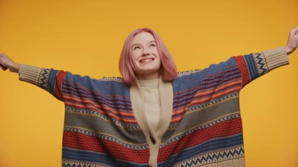 イエローバックグラウンドで功績を挙げた女性 ポジティブな感情で育ったピンク髪の若い学生アーム — ストック動画