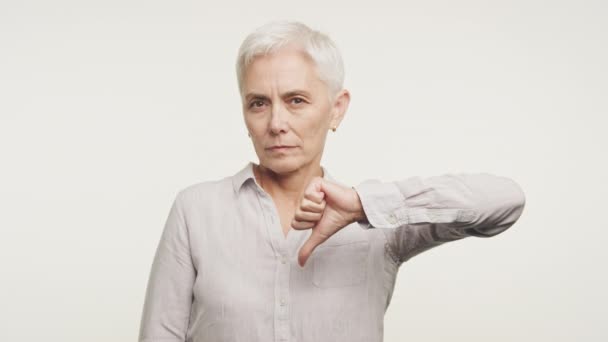 Senior Kvinna Visar Tumme Ner Gesture Vit Bakgrund Gammal Vuxen — Stockvideo