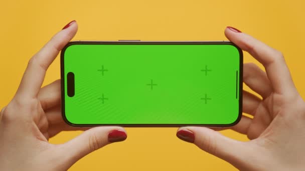 绿色屏幕智能电话Pov在黄色背景下的光学放大 带标志的 妇女手拿着横向色谱关键智能电话 — 图库视频影像