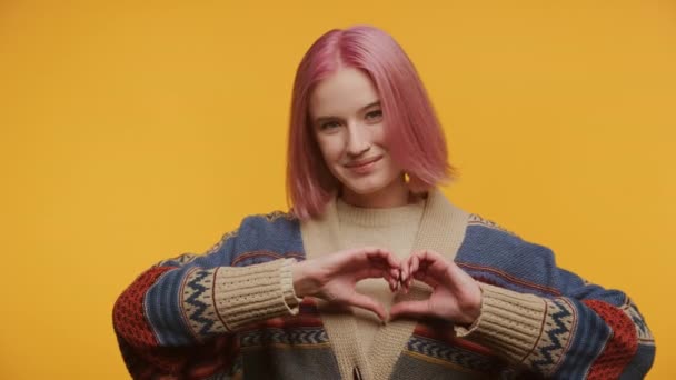 Jeune Femme Montrant Geste Coeur Sur Fond Jaune Cheveux Roses — Video