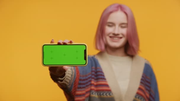 Vrouw Holding Green Screen Smartphone Gele Achtergrond Roze Haar Jonge — Stockvideo