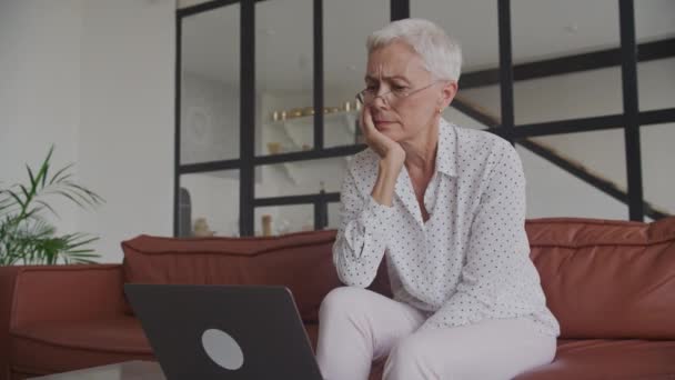 Pensive Senior Woman Lecture Mauvaises Nouvelles Sur Ordinateur Portable Intérieur — Video