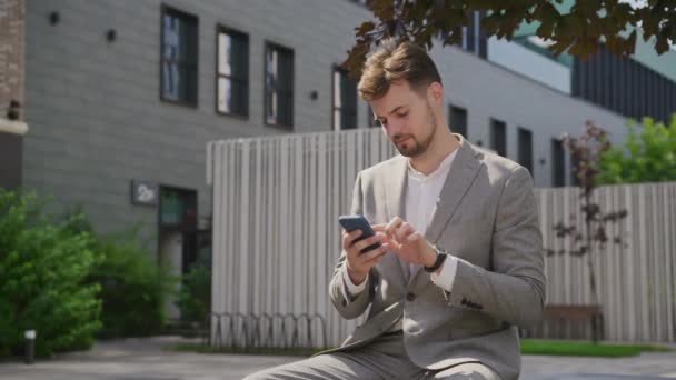 Şehir Merkezindeki Açık Havada Akıllı Telefon Kullanarak Adamı Internette Geziniyor — Stok video