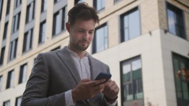 Smartphone 'da Man Browsing Çevrimiçi Açık Sokak' ta Düşük Açı Görünümü