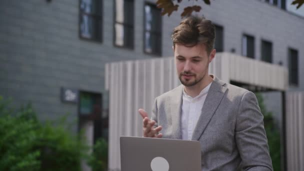 ビデオ会議で話す自信のあるビジネスマン 外でラップトップを使用してコール — ストック動画