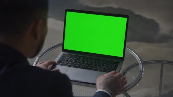 商人在办公室里看彩色键笔记本电脑 越过肩膀观看绿色屏幕电脑的人 — 图库视频影像