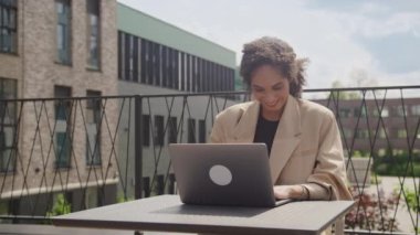 Dışarıda Dizüstü bilgisayar kullanan heyecanlı iş kadını