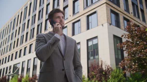 外で電話で話す自信のあるビジネスマン — ストック動画