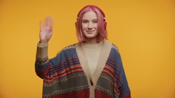 Woman Waving Hand Greeting Gesture Κίτρινο Φόντο Κόκκινα Ακουστικά — Αρχείο Βίντεο