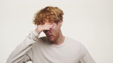 Başı dertte olan adam, Beyaz Arkaplanda Ginger 'ı üzüyor. Yakın plan.