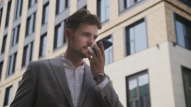 スマートフォンアウトドアを使用したビジネスマンレコーディング音声メッセージ — ストック動画