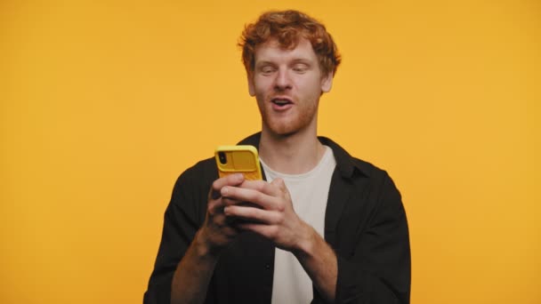 Upset Man Lezen Negatieve Boodschap Smartphone Gele Achtergrond — Stockvideo