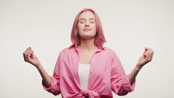 Žena Růžovými Vlasy Meditativní Póze Klidným Výrazem Oči Zavřené Bílém — Stock video