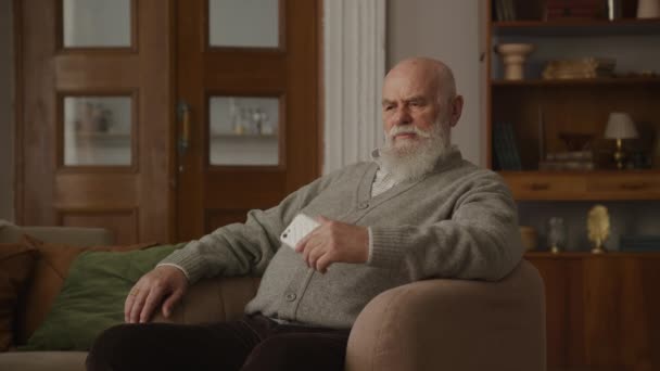Gedachte Oudere Man Met Een Witte Baard Zit Comfortabel Een — Stockvideo