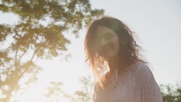 Verlicht Portret Van Een Glimlachende Vrouw Met Zonlicht Door Bomen — Stockvideo