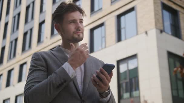 Focused Young Businessman Gray Suit Checks His Phone Urban Backdrop — Stock Video