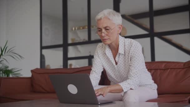 Mujer Madura Concentrada Con Gafas Usando Laptop Trabajando Desde Casa — Vídeos de Stock