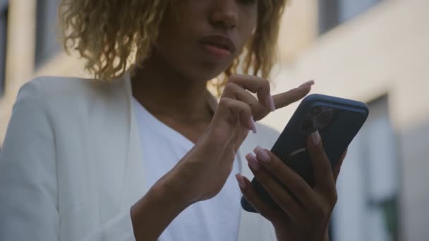 一位拿着智能手机的年轻女子 专心致志地看着屏幕 — 图库视频影像