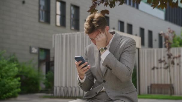 忧心忡忡的男人在城市里看智能手机 — 图库视频影像