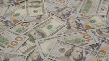 Zenginlik ve finansal kavramları tasvir eden dağınık 100 dolarlık banknotlar.