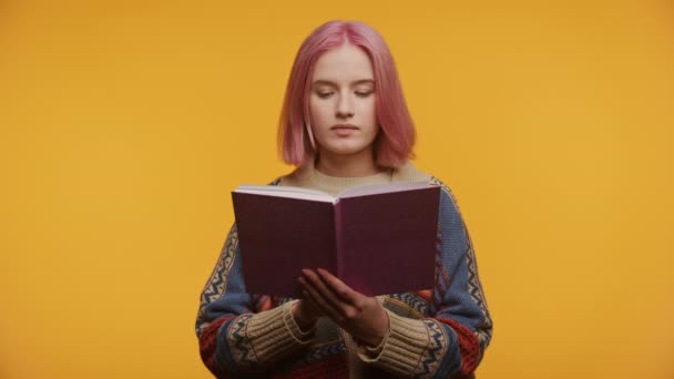 Зосереджена Молода Жінка Рожевим Волоссям Занурена Читання Книги Затишному Светрі — стокове відео