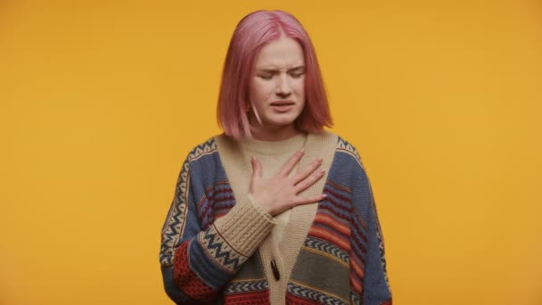 Молодая Женщина Розовыми Волосами Трогает Грудь Выглядя Расстроенной Желтом Фоне — стоковое видео