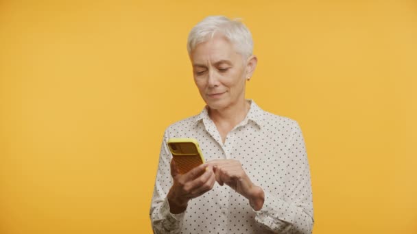 Senior Kvinna Njuter Smartphone Gul Exemplifiera Anslutning Och Glädje Den — Stockvideo