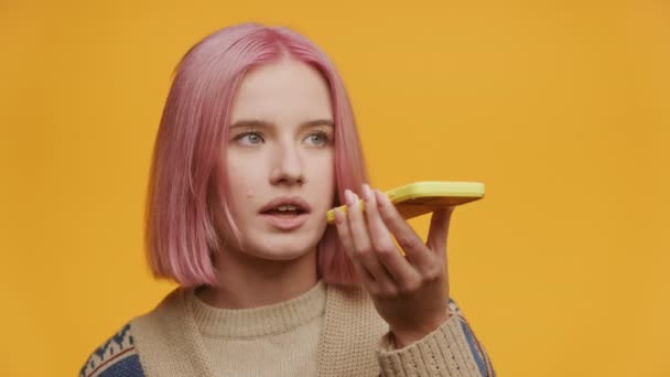 Glimlachende Jonge Vrouw Met Roze Haar Spreken Een Martphone Tegen — Stockvideo