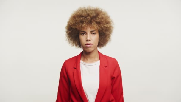 一个年轻女子的画像 有着自然的非洲式发型和大胆的红色外套 衬托着白色的背景 流露出自信和风格 — 图库视频影像