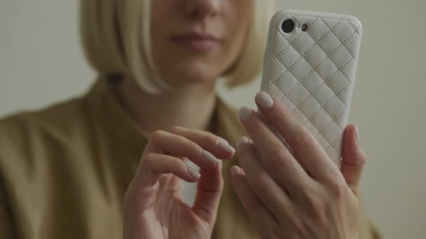 キルト付きのスマートフォンケースを保持している女性の手のクローズアップ — ストック動画