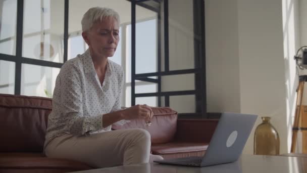 Zamyślona Dojrzała Dama Srebrnych Włosach Dopasowująca Okulary Ekranu Laptopa Prawdopodobnie — Wideo stockowe