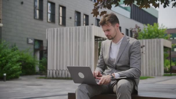 Mladý Profesionální Muž Zaměřil Svůj Notebook Zatímco Seděl Lavičce Městském — Stock video