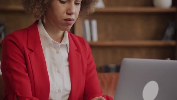 Intuitiv Fokussierte Frau Mit Lockigem Haar Roten Businessanzug Mit Laptop — Stockvideo