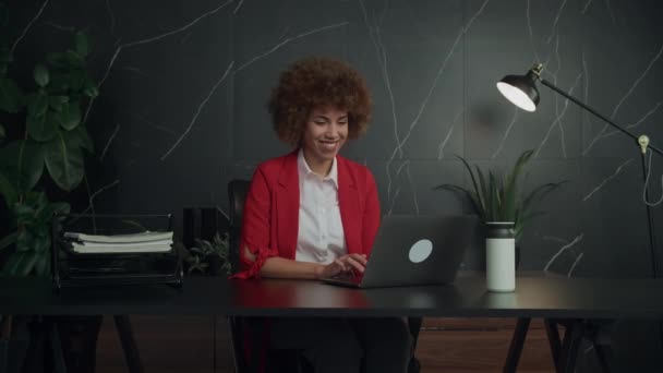 在一个灯火通明的现代办公室里 一位快乐的女商人在她的笔记本电脑上与绿色的植物一起工作 — 图库视频影像