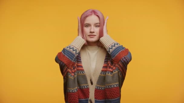 Junge Frau Mit Pinkfarbenen Haaren Händen Den Ohren Buntem Pullover — Stockvideo