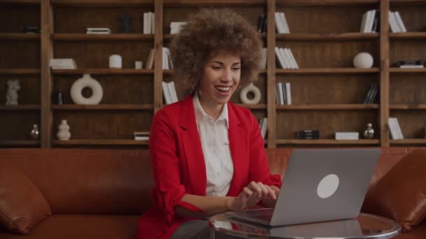 Улыбающаяся Женщина Вьющимися Волосами Помощью Ноутбука Одетая Красный Блейзер Современной — стоковое видео