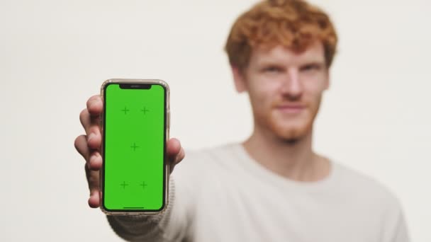 Mladý Muž Ukazuje Telefon Zelenou Obrazovkou Vhodný Pro Výměnu Obsahu — Stock video