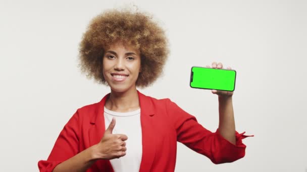Lächelnde Frau Hält Ein Smartphone Mit Grünem Bildschirm Hoch Und — Stockvideo