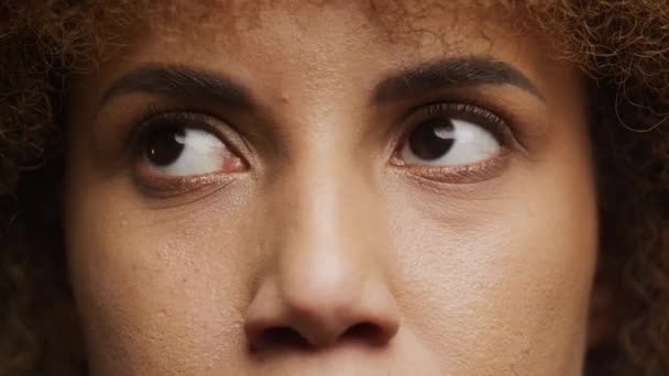 女性の目の詳細なクローズアップ 自然な肌の質感とカーリーな髪の見た目の側面を示す — ストック動画