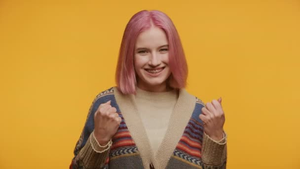 Neşeli Pembe Saçlı Gülümseyen Yumruklarını Sıkan Genç Bir Kadının Portresi — Stok video