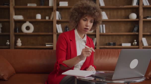 Poważna Kobieta Czerwonej Kurtce Pracująca Pisząca Notatki Przy Laptopie Biurze — Wideo stockowe