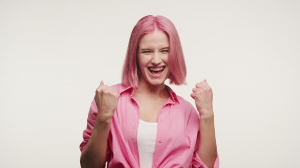 Экстатичная Женщина Розовыми Волосами Радуется Кулаками Поднятыми Белом Фоне — стоковое видео