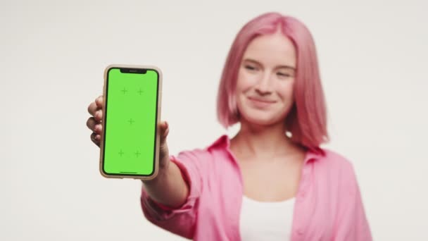 Wanita Menyajikan Ponsel Dengan Layar Hijau Kroma Kunci Terhadap Latar — Stok Video