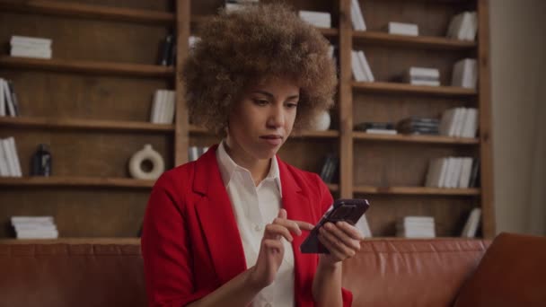 Pensive Professionele Vrouw Een Rode Jas Kijken Naar Haar Smartphone — Stockvideo