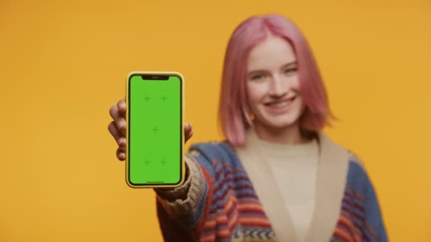 Radosna Młoda Kobieta Różowymi Włosami Wzorzystym Swetrem Trzyma Smartfona Zielonym — Wideo stockowe