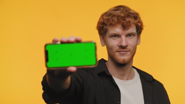Улыбающийся Мужчина Показывает Мобильный Телефон Цветным Экраном Ключа Желтом Фоне — стоковое видео